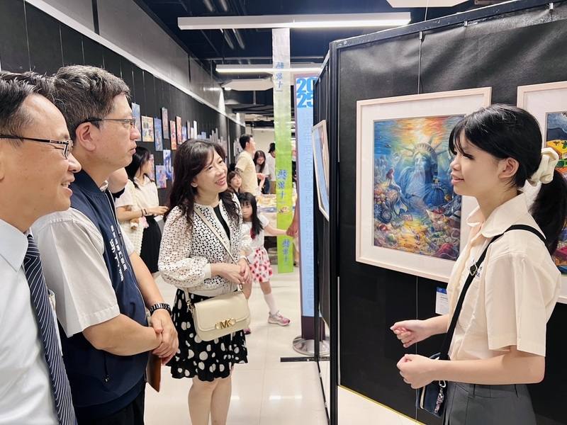 台北市政府教育局主辦的「台北市113學年度各級學校美術班學生作品聯合展覽」4日在松山機場正式展開，中正高中一年級學生周采亭（右）以漫畫手法描繪海洋遭污染後的孤單美人魚，作品取名為「末世的孤獨者」。（北市教育局照片）