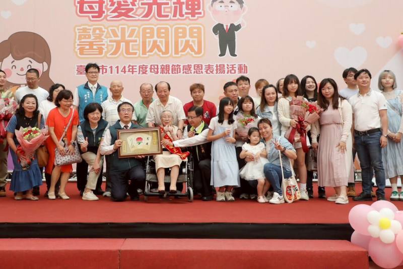 台南市政府4日舉辦母親節感恩表揚活動，家住安南區100歲慈暉媽媽吳王連照（前左5）是今年受表揚中最高齡母親代表，多名家族成員陪同出席，市長黃偉哲（前左4）親自頒獎。（市府提供）