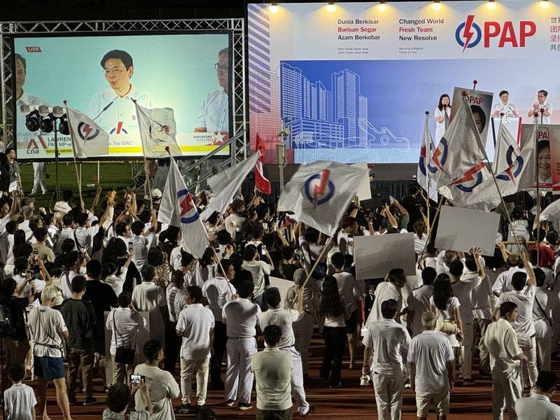 Singapore Prime Minister Lawrence Wong (second from right on stage) gives a speech after his party won a landslide victory in Sunday's general elections.