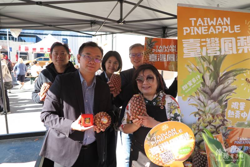 週未市集推廣臺灣金鑽鳳梨 。前排左起，農科院研究員羅國良、駐奧克蘭辦事處處長陳詠韶；後排左起，大洋洲臺灣商會聯合總會名譽總會長郭力銘、高登豪斯董事長翁靜慧、僑務委員施振嘉