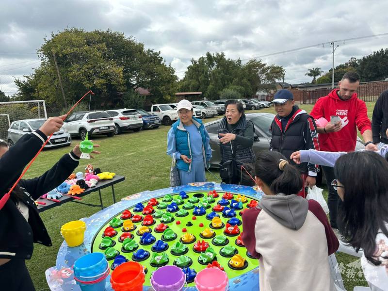 大小朋友參與抓魚遊戲攤位，現場洋溢歡樂笑聲