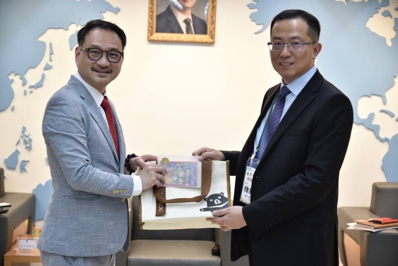 僑務委員會副委員長阮昭雄（左）致贈訪團禮品，由美京中華會館徐主席腕佑（右）代表接受