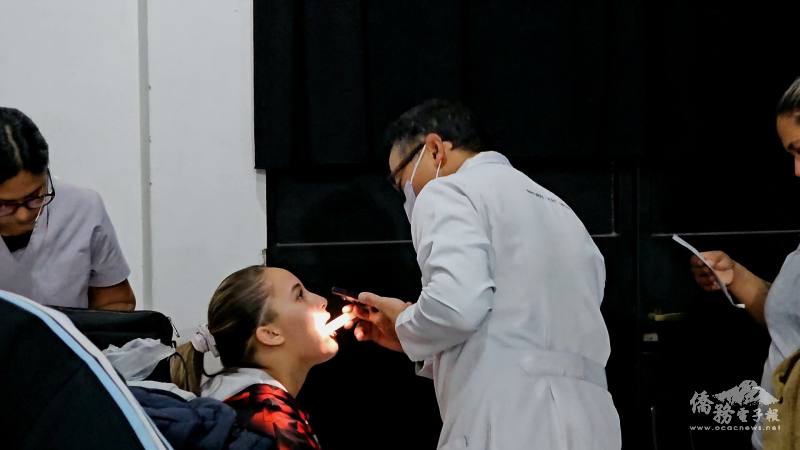 臺僑牙醫現場利用手機手電筒進行口腔初診，為在地孩童與家長提供專業建議與初步健康資訊，實踐Taiwan Can Help精神