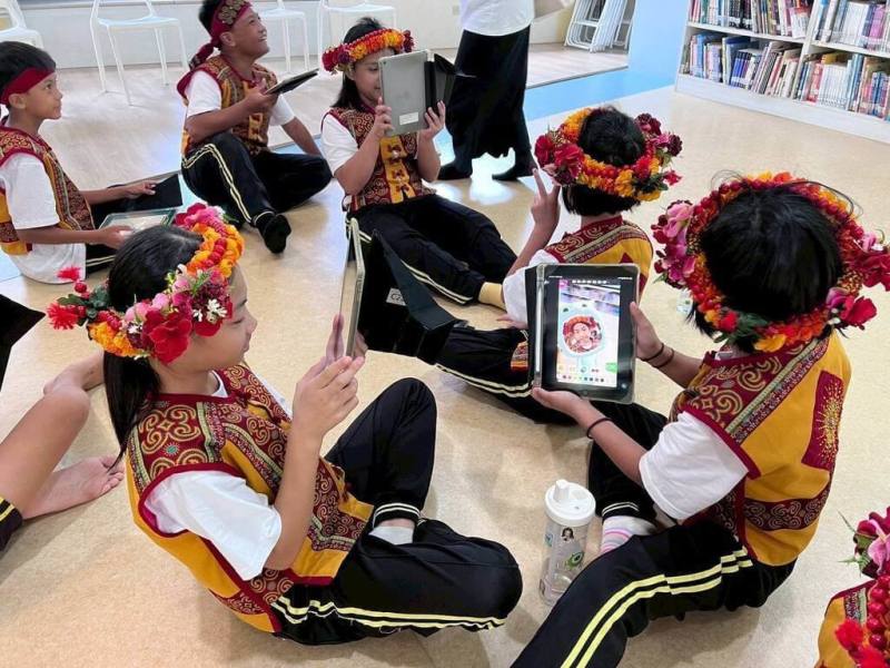 屏東縣北葉國小排灣歌謠隊走出山林，13日與高雄市河堤國小進行表演交流，北葉國小學生也參觀了河堤國小特色空間「河堤書齋」，並體驗AR互動遊戲。（河堤國小提供）