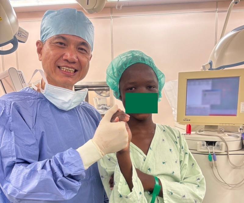 小清(右)手術後，雙眼裸視視力大幅提升，變得愛笑又有自信。左為孫啟欽醫師。(長庚醫院提供)
