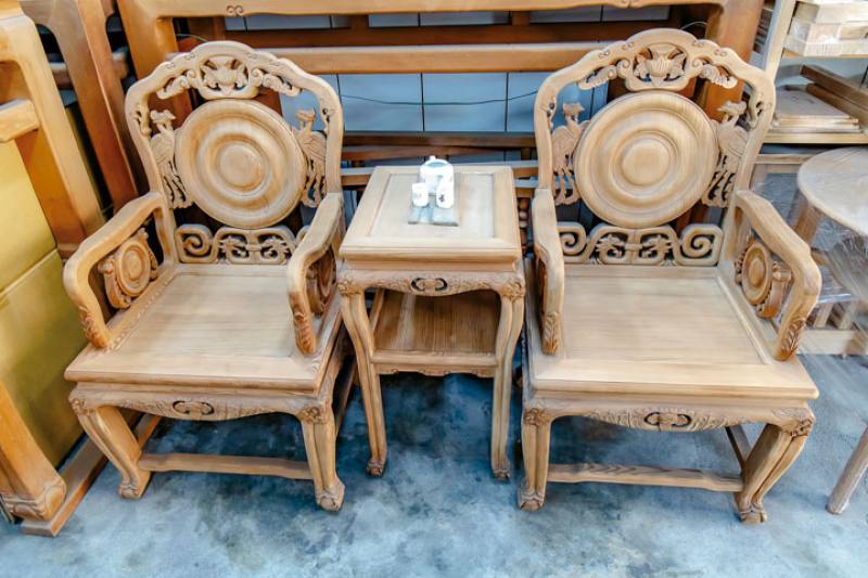 This hand-carved chair and table set, made from Taiwan cypress, is a product of the Xinquan furniture shop. The smooth lines and vivid carvings are reminiscent of Ming-Dynasty furniture.