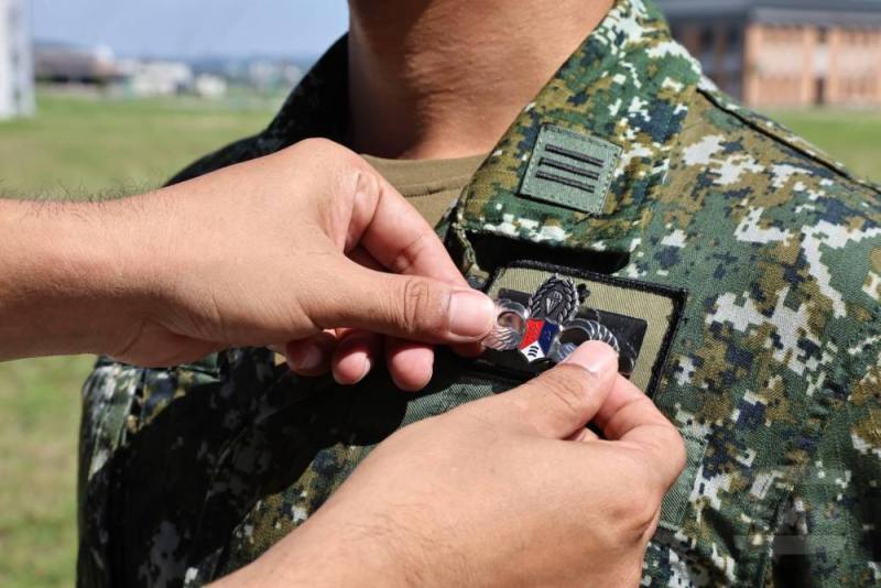 傘教組教官為學員別上銀白色的「鐵漢傘徽」。（青年日報提供）