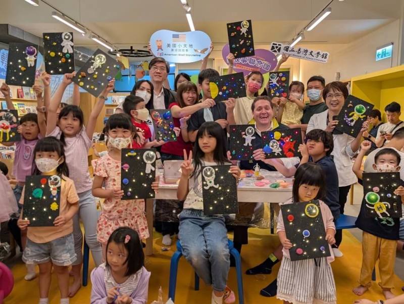 台灣文學館辦理「故事聯合國」系列活動，17日邀請美國在台協會（AIT）高雄分處長張子霖（後中右）為小朋友說故事，現場氣氛熱絡。（國立台灣文學館提供）