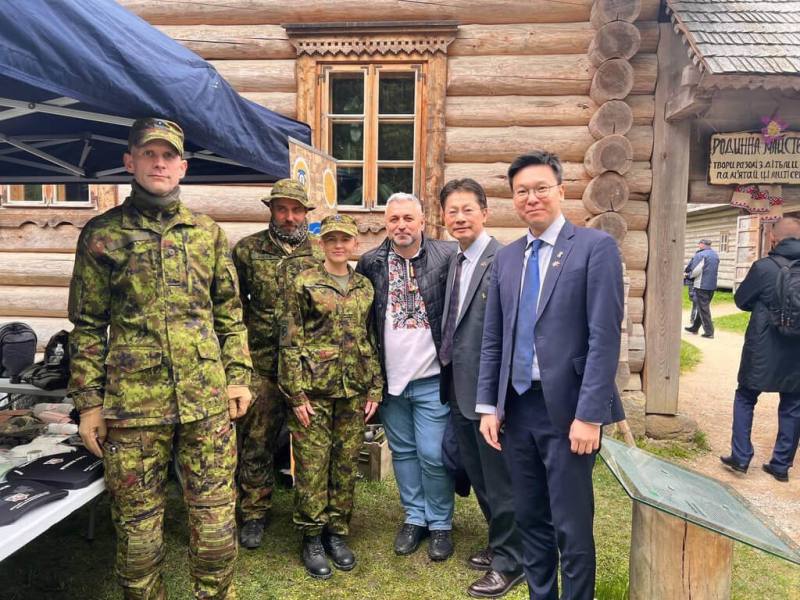 國安會副秘書長林飛帆（右1）參加「刺繡衫節-維希凡卡團結」嘉年華活動，參觀愛沙尼亞防衛聯盟展示軍事裝備和器材的攤位，並與駐拉脫維亞代表李憲章（右2）、「烏克蘭人在愛沙尼亞組織協會」主席帕拉瑪（右3）合影。（駐拉脫維亞代表處提供）