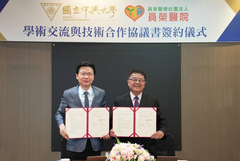 中興大學21日與員榮醫院簽署學術交流與技術合作協議書（MOU），由興大校長詹富智（右）與員榮醫院總院長張克士（左）代表雙方簽約。（中興大學提供）
