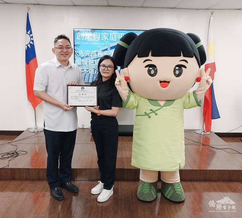 菲華文教中心主任莊博智(左)頒贈感謝狀給「二嫂企業」負責人姚慧貞(中)；右方為企業吉祥物「二嫂娃娃」