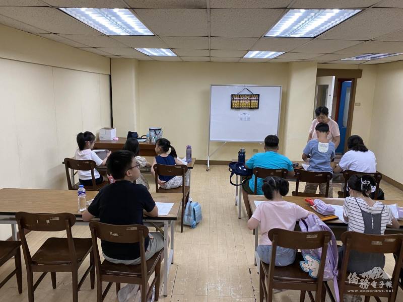 老師施子莉指導學生進行珠算練習，學生專注投入，氣氛熱絡