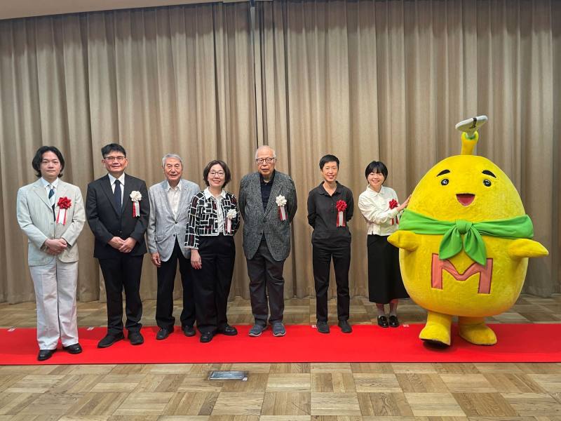 文化部次長王時思（左4）、手塚製作公司董事長松谷孝征（左3）、國家漫畫博物館籌備處代理主任陳登欽（左2）、京都國際漫畫博物館館長荒俁宏（右4）、慢工出版總編黃珮珊（右3）、臺灣漫畫家高妍（右2）、日本漫畫家川勝德重（左1）、京都國際漫畫博物館吉祥物Mamyu（右1）合影（駐日臺灣文化中心提供）