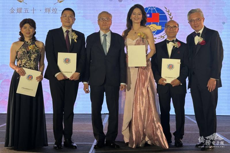 僑委會副委員長張良民（左3）頒贈新任會長彭鈺絢（左1）、劉明岳（右2）賀狀，滿任會長汪蔚興（左2）、張郁芬（右3）感謝狀