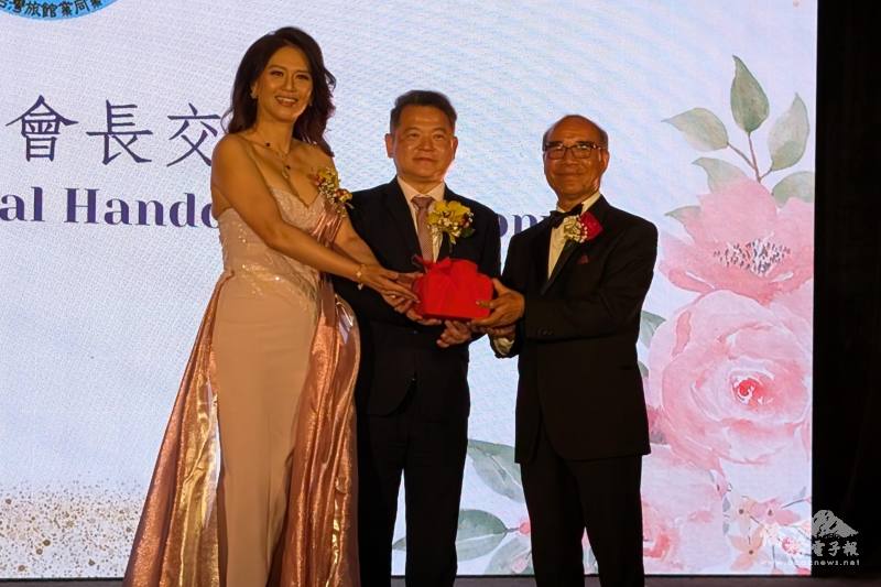 在洛杉磯辦事處處長紀欽耀監（中）交下，滿任會長張郁芬（左）將印信交予新任會長劉明岳（右）