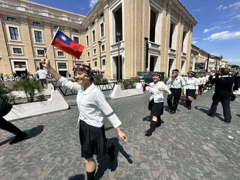 台灣「原聲童聲合唱團」26日前往梵蒂岡演出，孩童先在聖伯多祿大教堂前方的協和大道表演歌曲，接著一路舉著國旗前進，活潑可愛模樣引起許多各國民眾關注。（駐教廷使館提供）