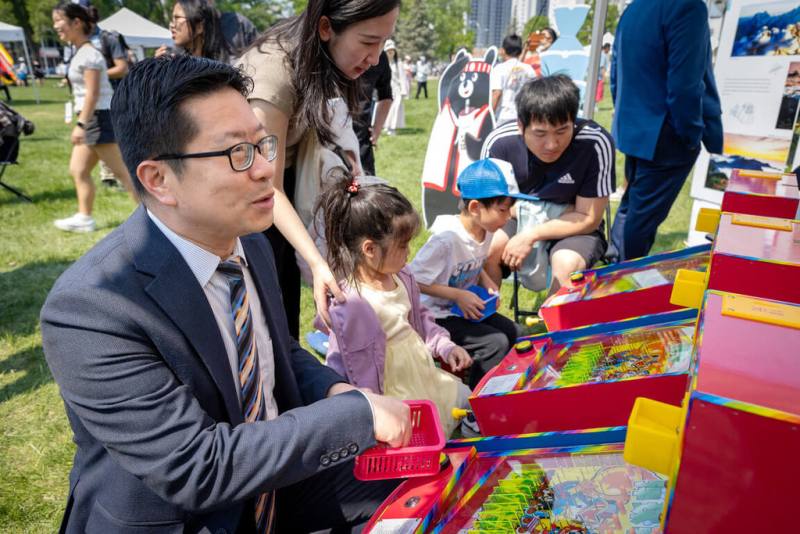 多倫多僑教中心主任藍柏青在曼尼托巴省「亞洲文化美食節」活動上，回味台灣童玩。（駐多倫多辦事處提供）