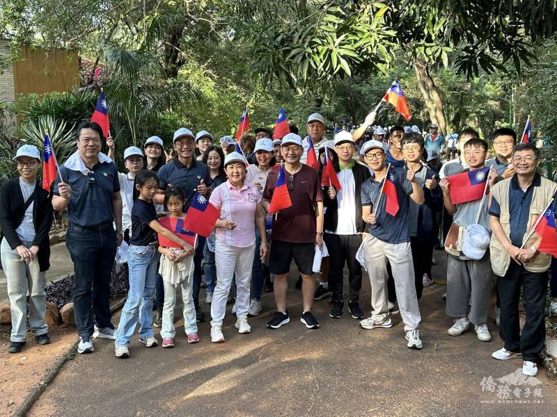 中華民國駐巴拉圭共和國大使韓志正(中著棕色衣)、僑務委員古美桂(中著粉紅色衣)與參與者行進間揮舞國旗，支持臺灣(駐巴拉圭大使館提供)
