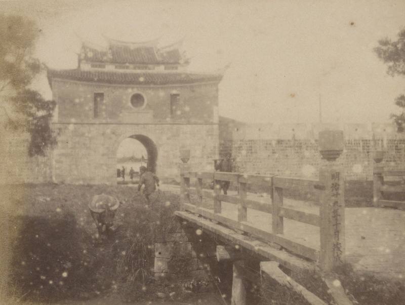 臺北大南門__影像中的南門為閩式城樓建築的樣貌，主體為兩層屋檐的歇山重檐式建築，以紅磚砌成，城門臺座為安山岩石材所建。城門的出入口連接著一座木橋，橋的欄杆上清楚標示著「明治二十九年十月竣成」，為1896年日本領臺第2年時完成的橋樑建築。
