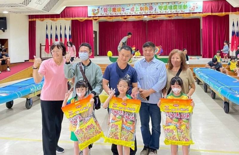 澎湖縣湖西鄉公所30日與鄉立幼兒園與圖書館共同舉辦「親子慶端午．陸上划舟趣」活動，以SUP立槳板改裝為陸上龍舟，有80對親子分組下場齊力比划，鄉長陳振中（2排右2）頒獎給優勝者。（澎湖湖西鄉公所提供）