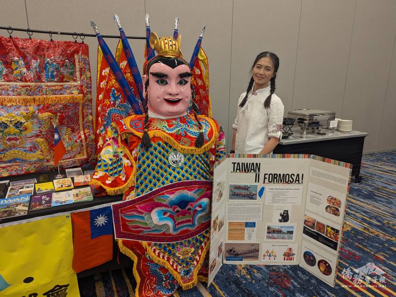 志工莊晴文與臺灣文化攤位一隅合影