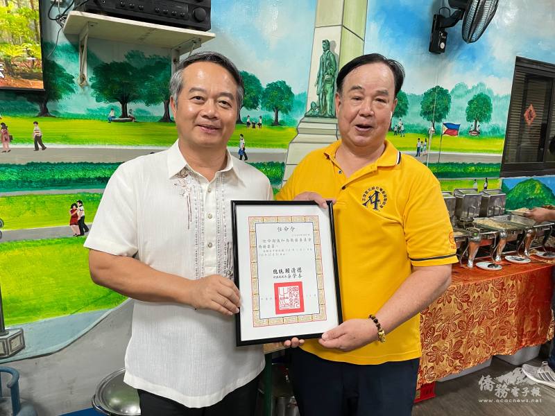 駐菲律賓代表處大使周民淦（左）代表中華民國政府頒發僑務委員任命令予北線臺灣廠商聯誼會創會會長謝儀和（右），表彰其對僑界的長期貢獻