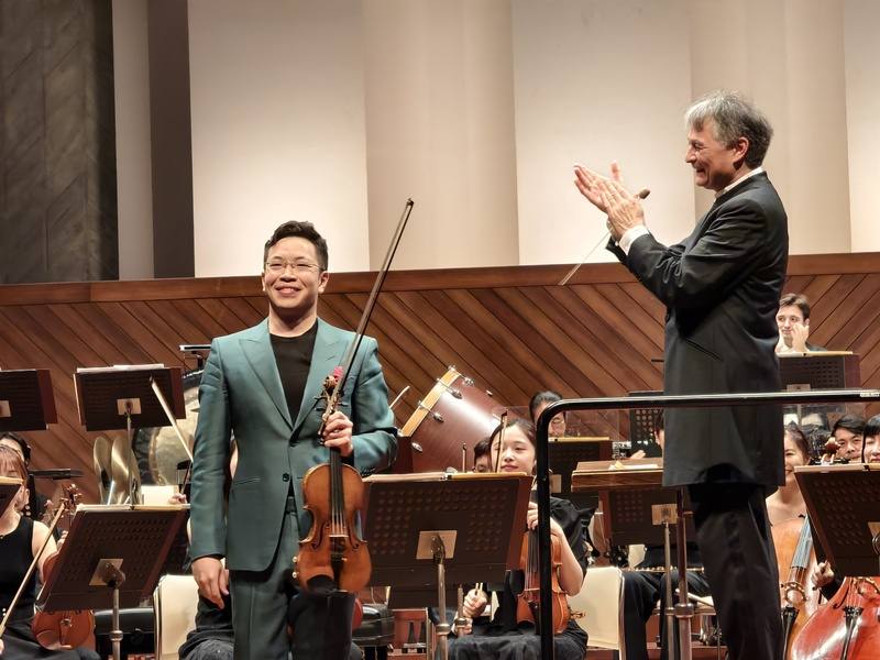 NSO國家交響樂團31日在日本熊本縣立劇場舉行「來自台灣」日本巡演音樂會首場演出，指揮準．馬寇爾（Jun Märkl）（右）與小提琴家黃俊文（左）首度合作演出貝多芬「D大調小提琴協奏曲」