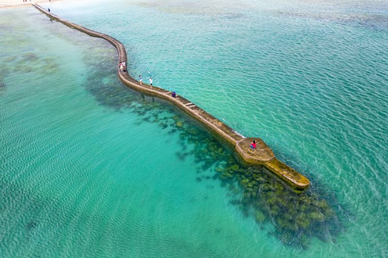 澎湖百大亮點「後寮」以碧海藍天的海中步道「天堂路」聞名，每到漲潮許多遊客前來散步觀海（圖：交通部觀光署提供）