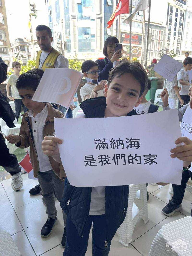 學生開心地高舉「滿納海是我們的家」標語，感謝所學校陪伴無數孩子成長築夢