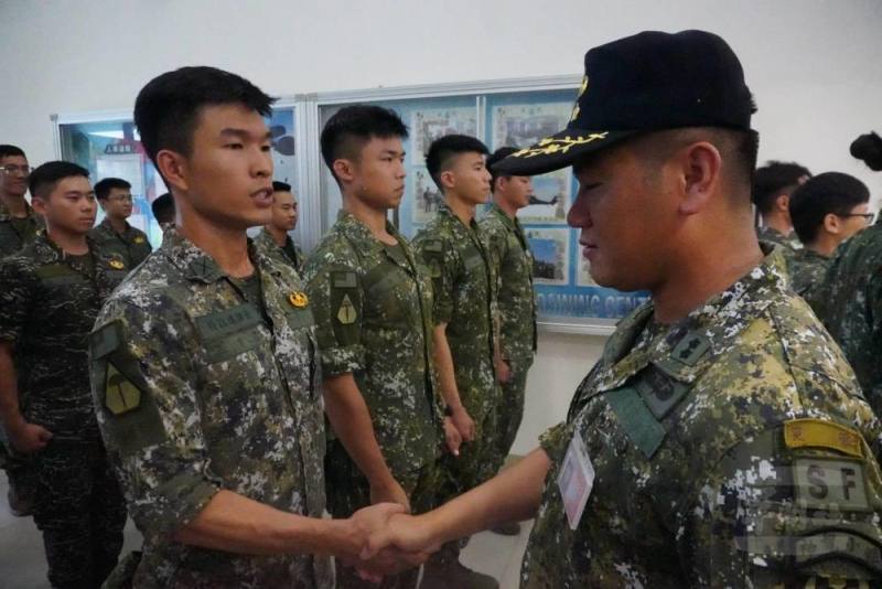 空訓中心傘教組教官為完訓學員別上傘徽。（青年日報提供）