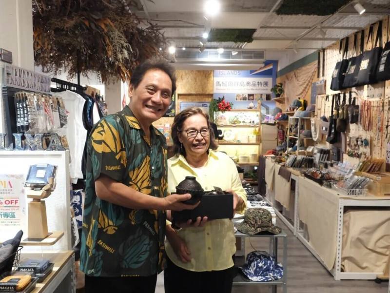 原民會主委曾智勇Ljaucu．Zingrur（左）4日在原民風格選物店LiMA接待馬紹爾總統海妮（Hilda C. Heine）（右）等一行，並致贈象徵和諧與祝福的陶壺給海妮。（原民會提供）