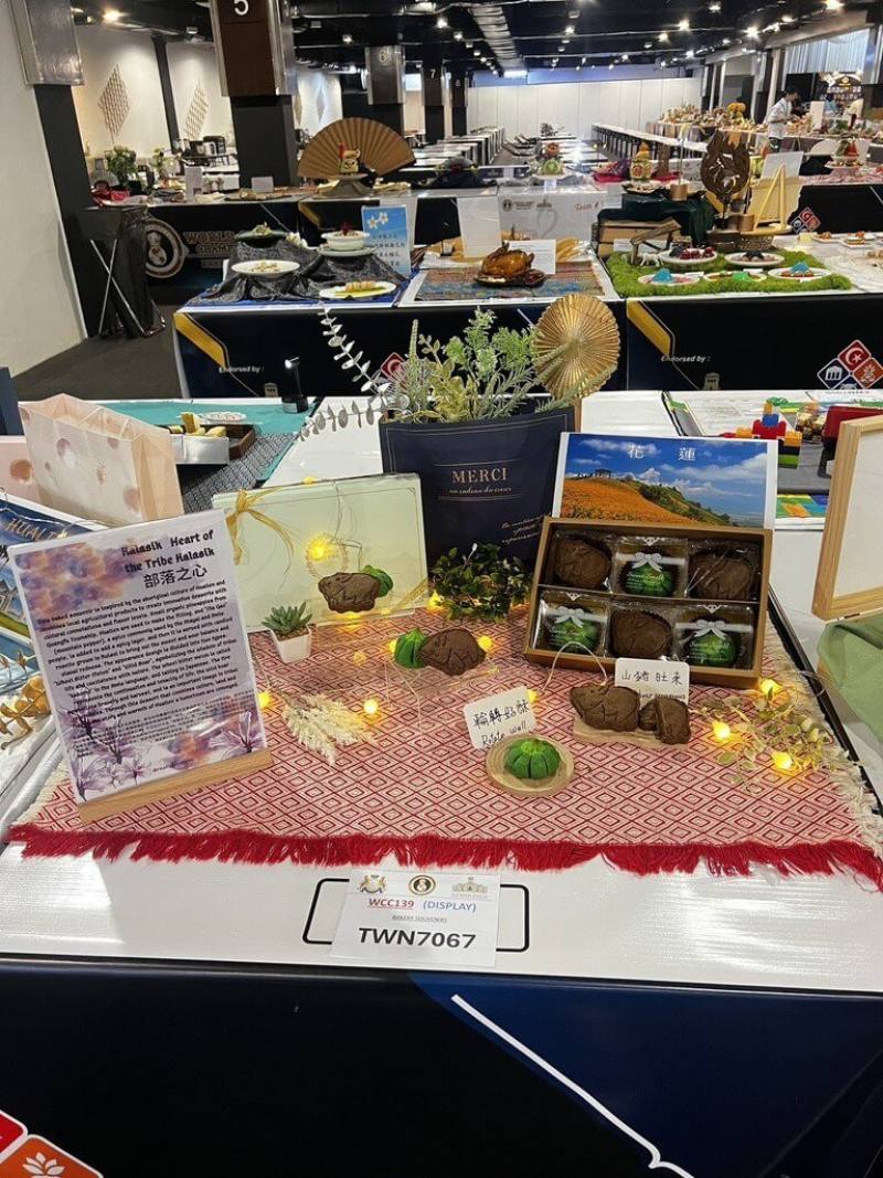 第4屆世界廚藝大賽日前在馬來西亞舉行，花蓮烘焙師黃湘涵以原民文化為靈感，選用光復有機鳳梨製成果餡，加入原民山胡椒馬告，佐以吉安及瑞穗栽種的洛神花蜜餞，外型則採車輪苦瓜與山豬造型，象徵部落生活與自然共生智慧，勇奪精緻觀光伴手禮組金牌。（花蓮縣文化局提供）