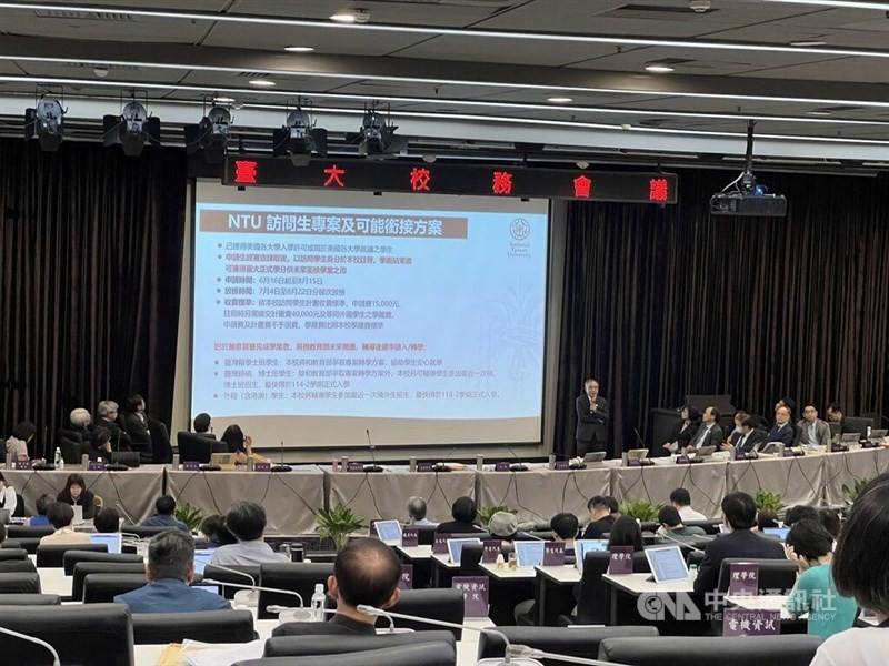 NTU President Chen Wen-chang (standing on the projector screen's right) announces a study program for students during Saturday's university council meeting. CNA photo June 7, 2025
