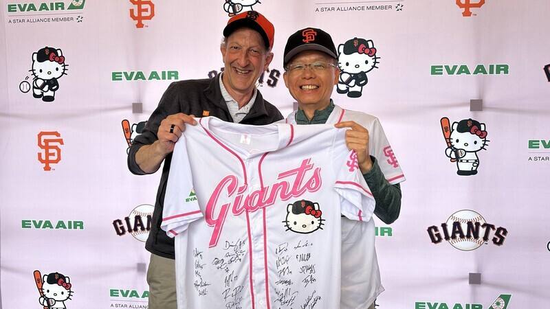 巨人隊執行長貝爾（左）致贈長榮航空總經理孫嘉明一件全隊球員簽名的Hello Kitty球衣。 (圖：中央社)
