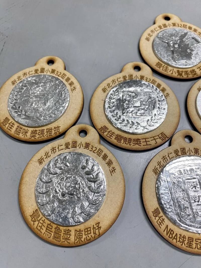 新北市仁愛國小民國114年畢業典禮的禮物相當特別，是由每名畢業生自行設計屬於自己的獎牌圖案與得獎名稱，並透過傳統錫工藝鑄造方式完成獨一無二的姓名金屬鑰匙圈。（新北市仁愛國小提供）