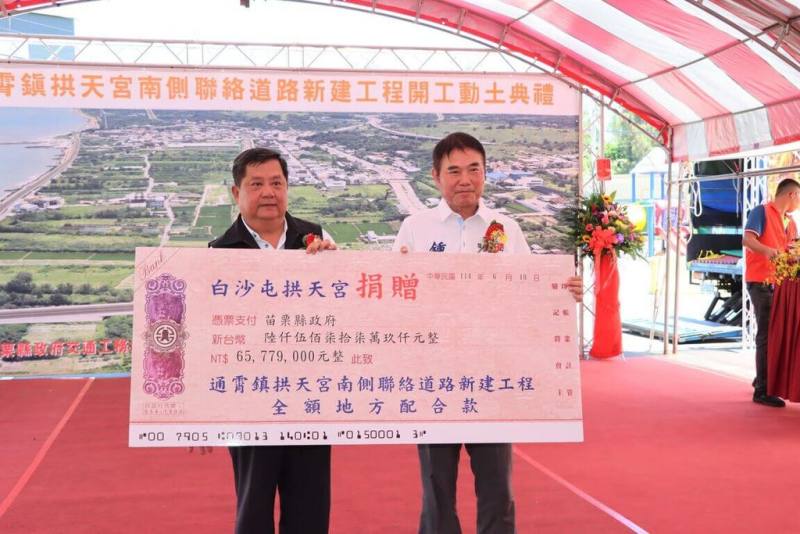 苗栗縣政府規劃白沙屯拱天宮南側聯絡道新建工程，10日舉辦動土典禮，總工程經費新台幣4億3853萬元，其中地方配合款6500餘萬元由拱天宮全數捐助。圖為拱天宮主委洪文華（左）代表捐贈，縣長鍾東錦（右）代表縣府表達感謝。（苗栗縣政府提供）