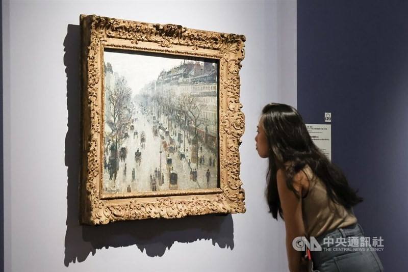 A woman views a painting on display at Taiwan's National Palace Museum during a press event held on Friday. CNA photo June 13, 2025