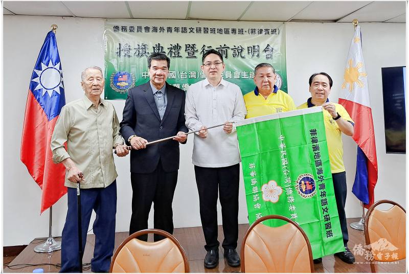 行前說明會中特別舉行授旗儀式，象徵菲律賓地區語文研習班正式揚帆啟航。出席嘉賓包括（由左至右）：僑務諮詢委員蔡慶華、菲華僑聯協會會長馮永恩、菲華文教中心主任莊博智、副會長許宏達及秘書長蔡聰敏