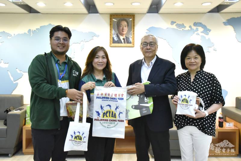 張良民(右2)、僑民處處長賴麗瑩(右1)與團長盧約安(左2)、柯明生(左1)互贈紀念品
