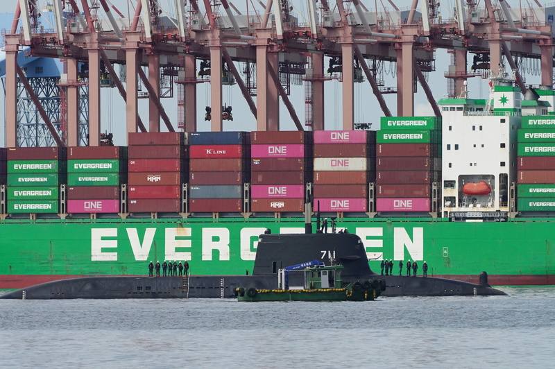 國造潛艦原型艦海鯤艦（圖）17日在高雄港內持續進行浮航，甲板上多名技術人員，一旁並有小船伴隨航行