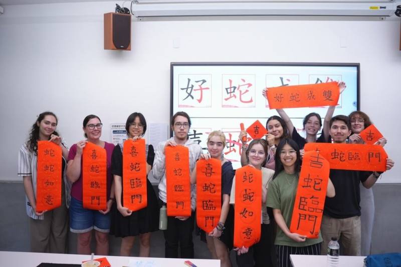 實踐大學近日迎接來自加拿大邁索納沃學院的22名學生，進行為期2週的密集華語課程，由於當時正逢端午假期，實踐華語中心安排一系列傳統文化活動，包括書法體驗等。（實踐大學提供）