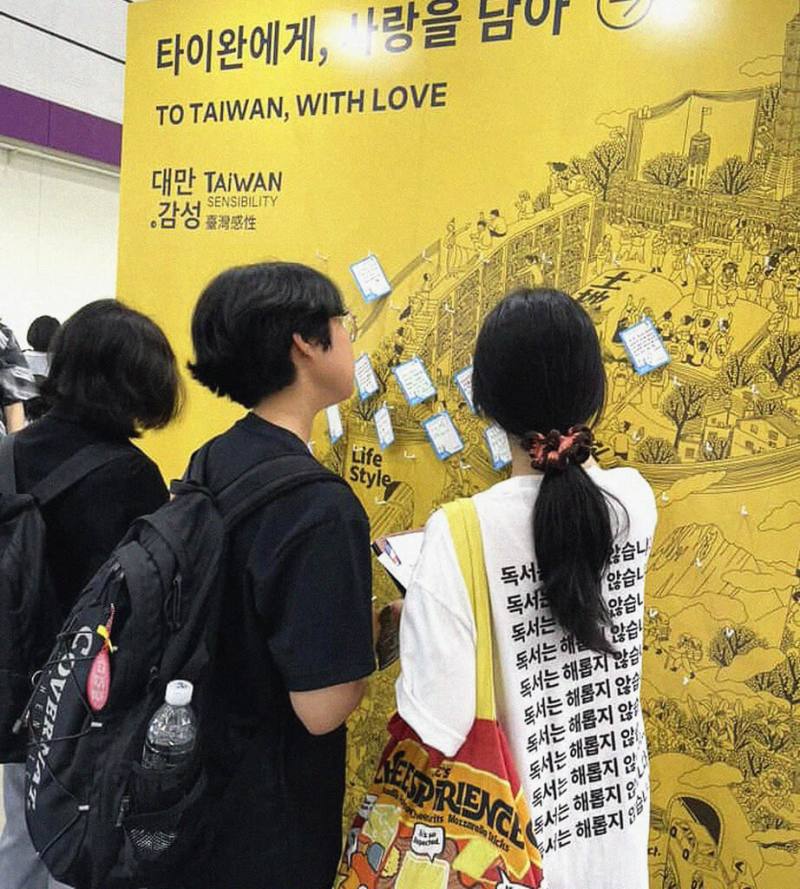 2025首爾國際書展18日在韓國首爾江南區COEX展覽中心開幕，台灣首次擔任主題國，共有23名跨領域作者前往參展。圖為韓國讀者在台灣館前留言牆上留下給台灣的祝福。（台北書展基金會提供）