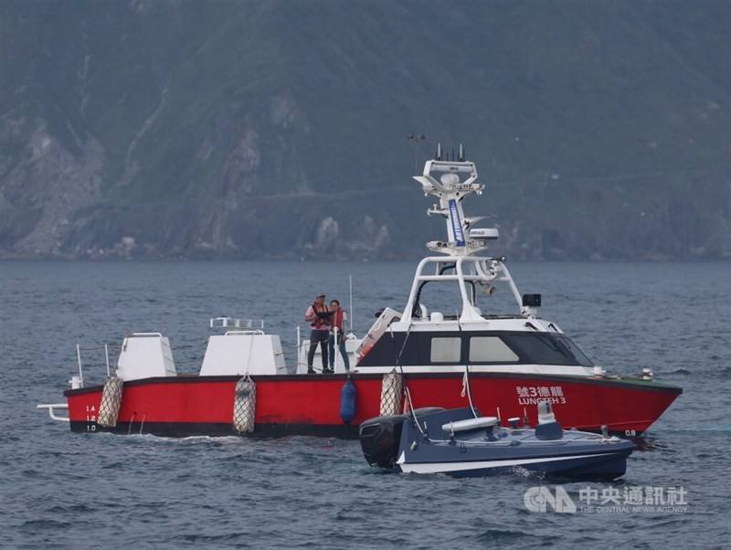 A man on a red boat maneuvers the Black Tide USV with a controller. CNA photo June 17, 2025