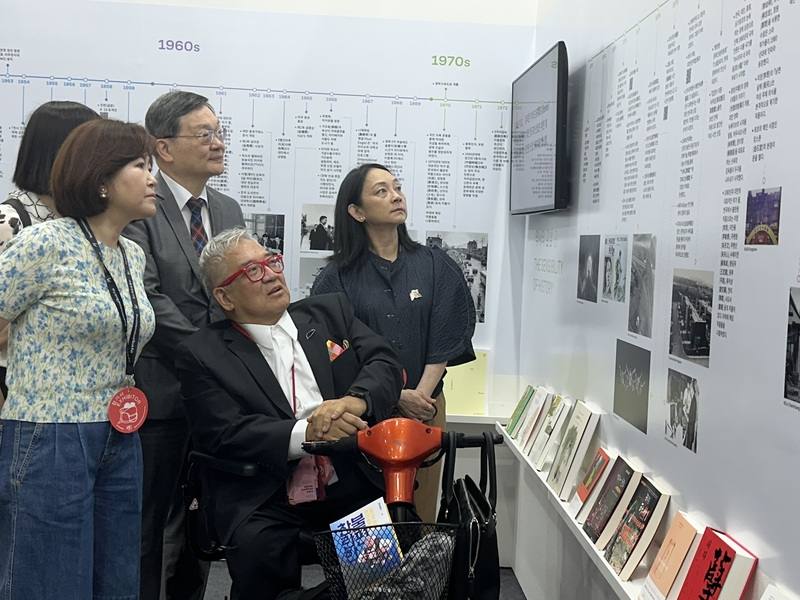 首爾大都會圖書館館長吳芝恩（前左）20日參觀首爾國際書展台灣館，台北書展基金會董事長郝明義（前右）以韓文導覽