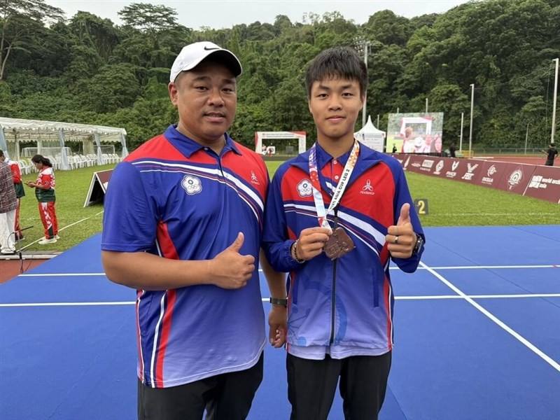 Taiwanese archer Chen Pin-an (right) poses with his bronze medal alongside his coach on Friday. Photo courtesy of the Chinese Taipei Archery Association