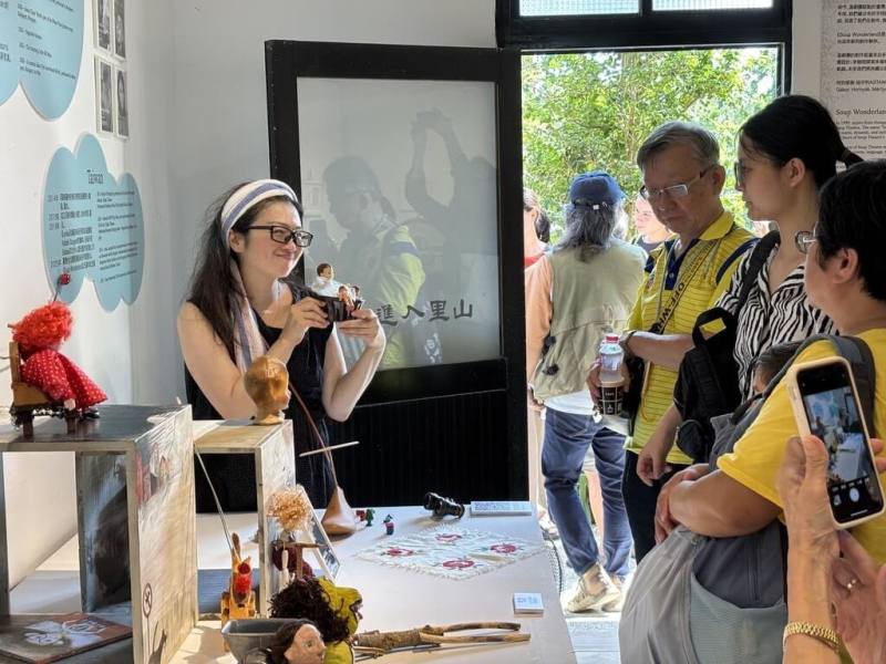 湯劇團「Soup Wonderland：湯劇團25週年的偶戲旅程」展覽22日在新北市三芝區陽住國際山海藝術中心開幕，團長許嘉芬（左）進行導覽，讓參觀者得以近距離欣賞創作細節。（湯劇團提供）