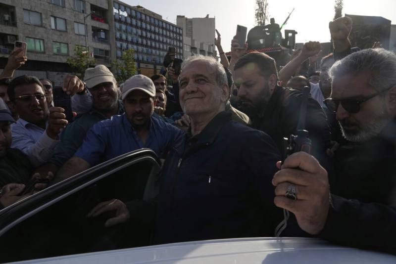 伊朗德黑蘭街頭爆發反美抗議潮，伊朗總統裴澤斯基安（中）也現身集會。（美聯社）