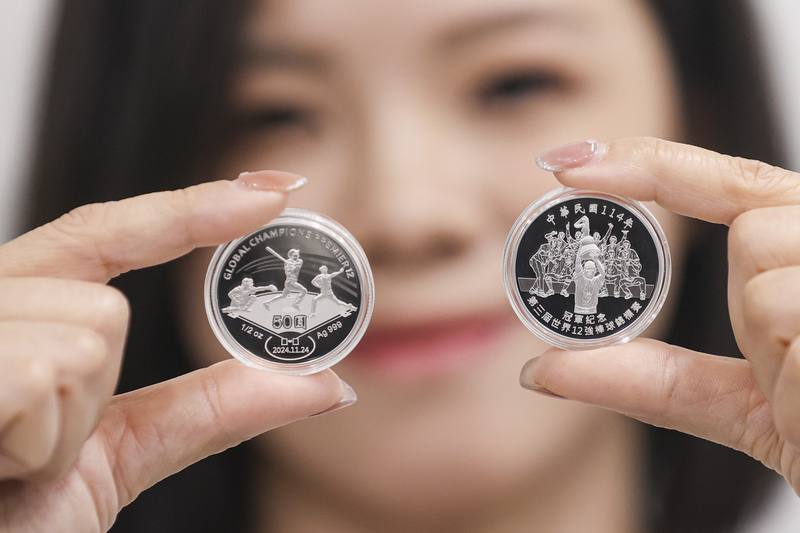 A woman displays the front and back of a Premier12 Championship commemorative coin during a news conference on Monday. CNA photo June 23, 2025