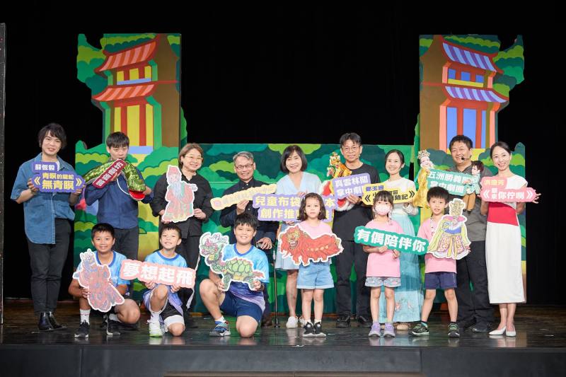 首屆「兒童布袋戲劇本創作推廣計畫」入選作品試演發表記者會合照，第一排左起為三玉國小~真雲林閣掌中劇團團長李京曄、編劇鄭玉姍、五洲勝義閣掌中劇團團長曾嘉民、編劇洪瓊芳。