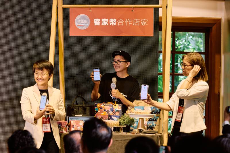 客委會古秀妃主委(左)與數發部主秘胡貝蒂(右)，親自示範客家幣的使用